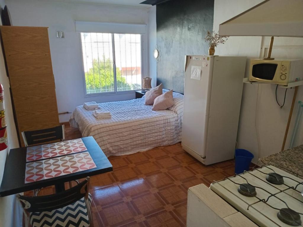 a kitchen with two beds and a refrigerator at Departamentos Perla del mar in Las Grutas