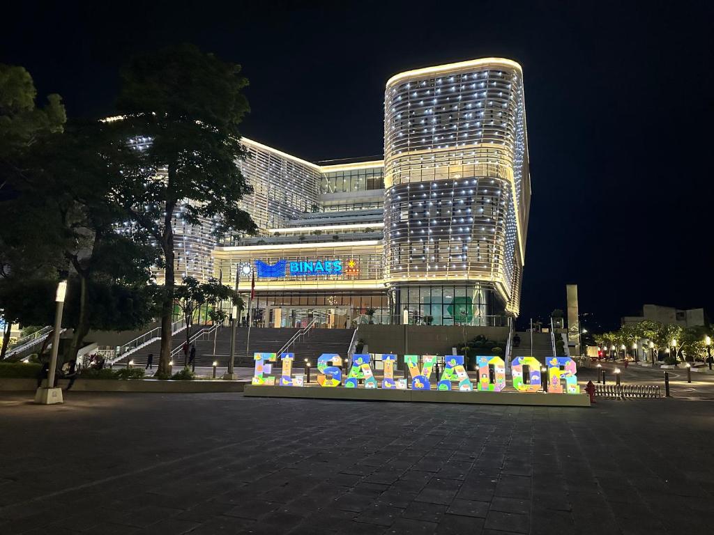 Un gran edificio con un cartel delante. en Zona Rosa San Benito 1 cuartito, en San Salvador