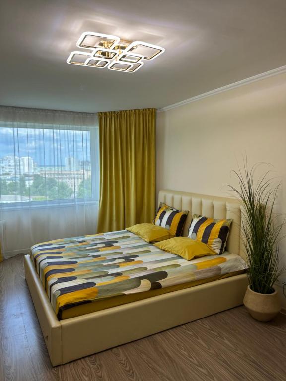 ein Schlafzimmer mit einem großen Bett mit Decke in der Unterkunft Стильна та затишна однокімнатна квартира на бульварі Шевченка с кондиціонером,поруч парковка з охороною in Tscherkassy