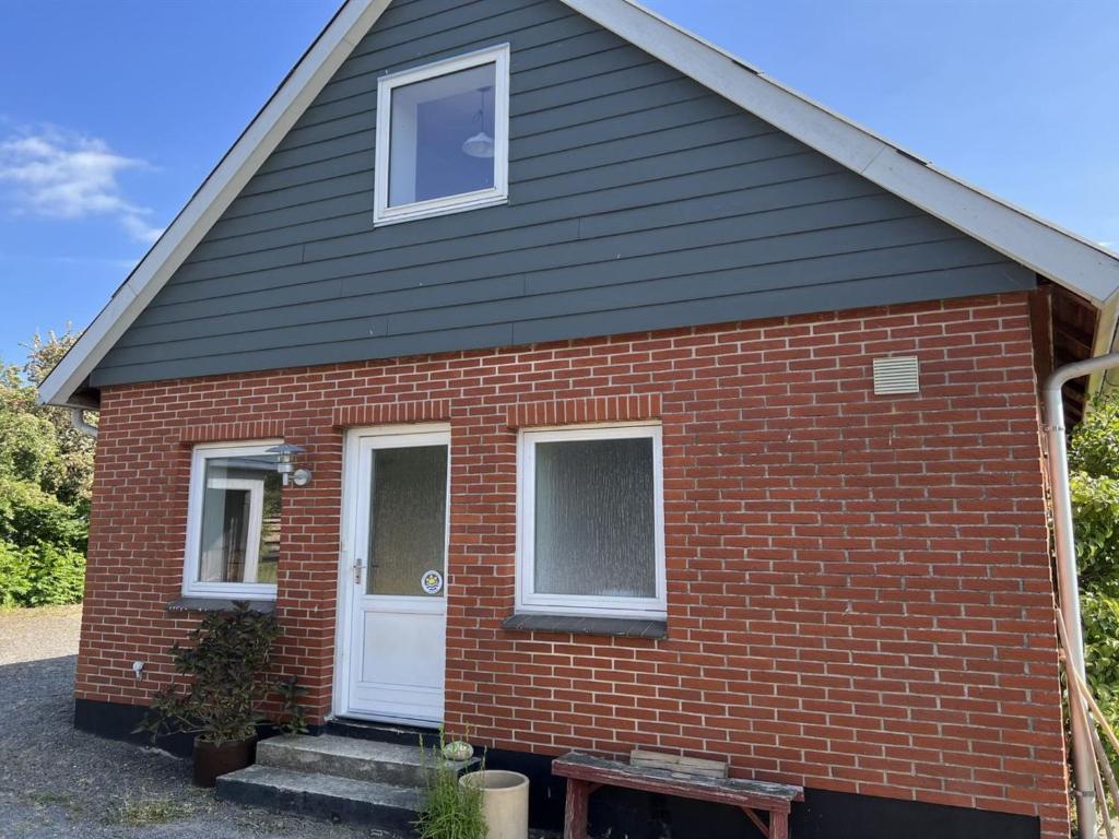 una casa de ladrillo rojo con puerta blanca en Apartment Riitta - 250m from the sea by Interhome, en Neksø