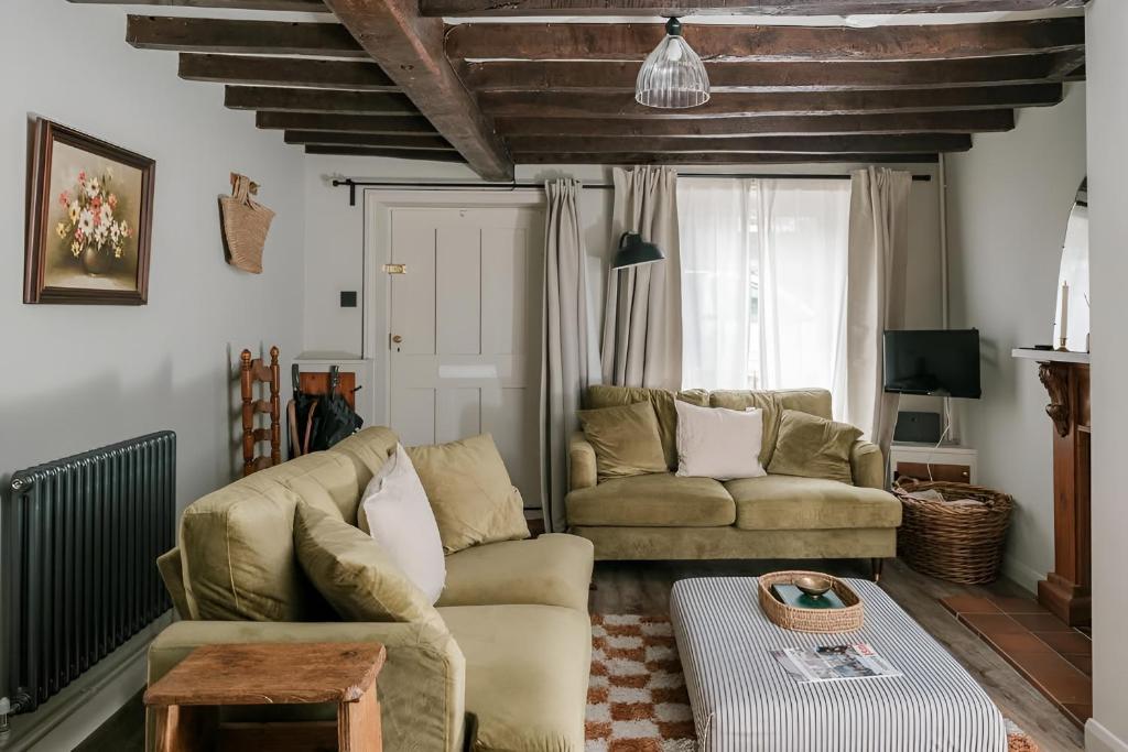 un salon avec un canapé et une table dans l'établissement 28 Millgate Cosy Dog Friendly Cottage in Aylsham, à Aylsham