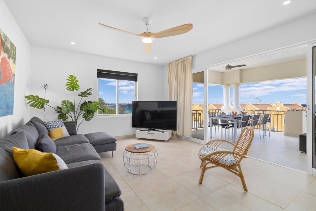 a living room with a couch and a tv at Playa Breeze Apartment in Kralendijk