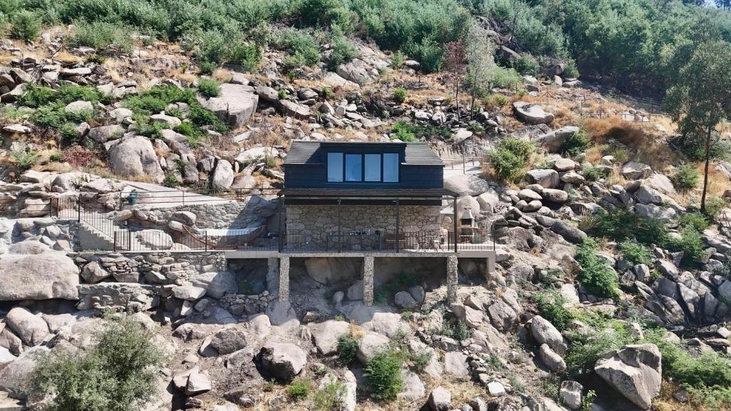 a house on top of a rocky mountain at Gardunha Stone in Louriçal do Campo