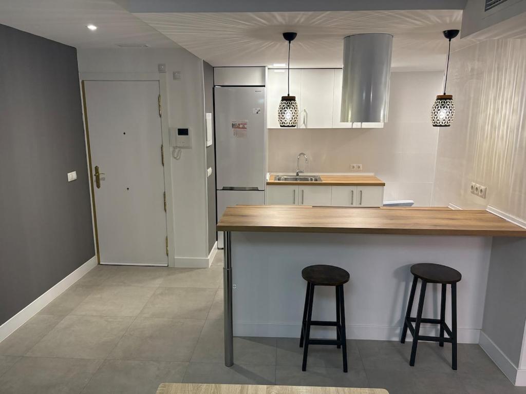 a kitchen with a counter and two bar stools at Apartamento en el centro de Móstoles in Madrid