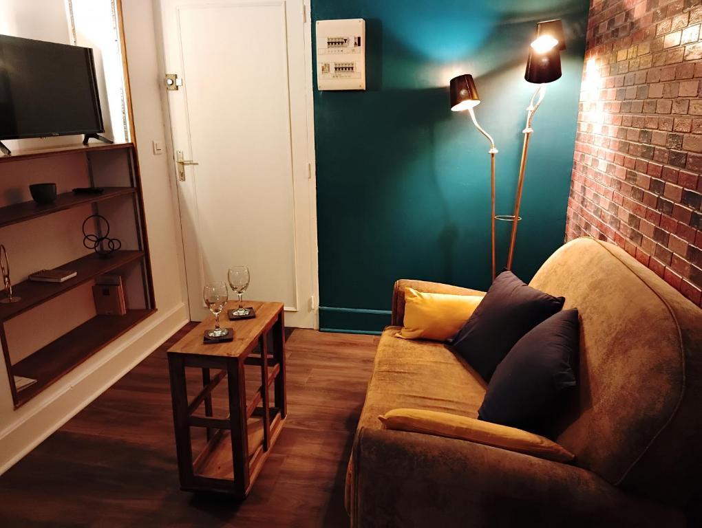 a living room with a couch and a table at La Petite Fabrique in Villedieu-sur-Indre