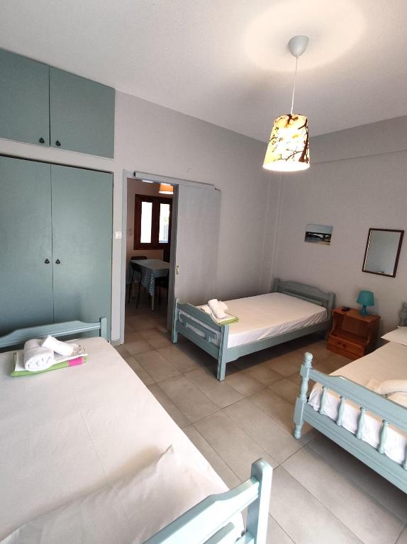 a bedroom with two beds and a light fixture at Apartments Konstantinidis in Nea Potidaea