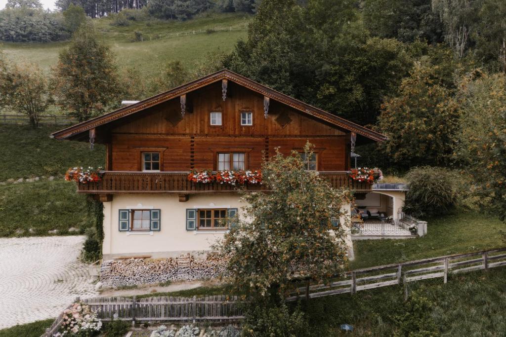 a wooden house with flowers on the balcony at Almrausch in Alpendorf
