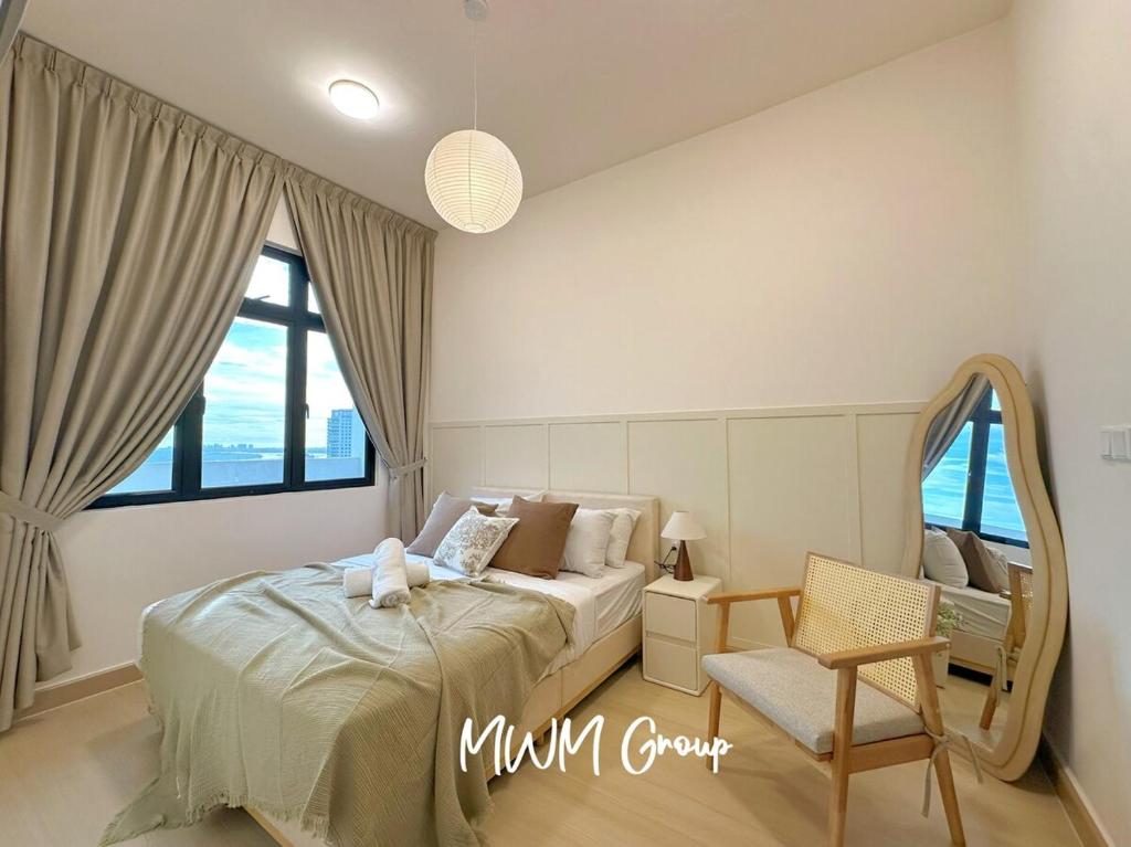 a bedroom with a bed and a chair and windows at Meldrum Heights Muji Creamy House Walks to CIQ in Johor Bahru