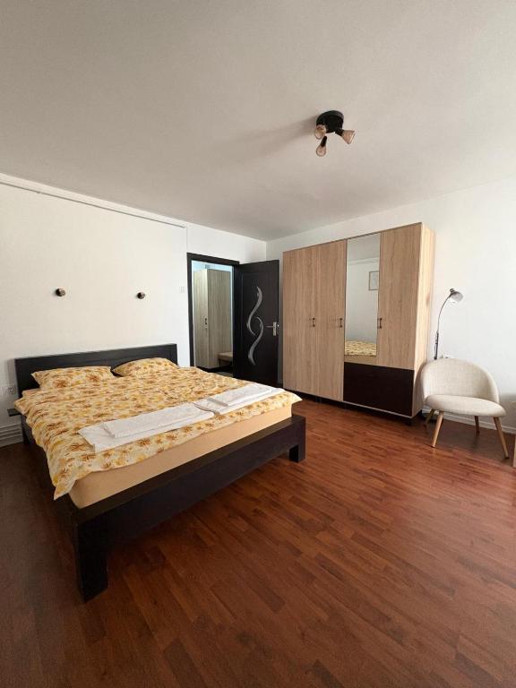 a bedroom with a bed and a chair in it at Comodo Studio in Turda