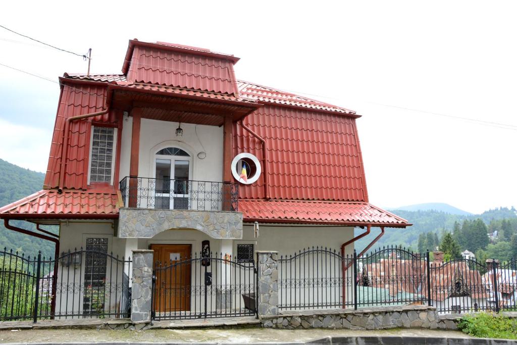 una pequeña casa con techo rojo y puerta en Casa Ana, en Sinaia