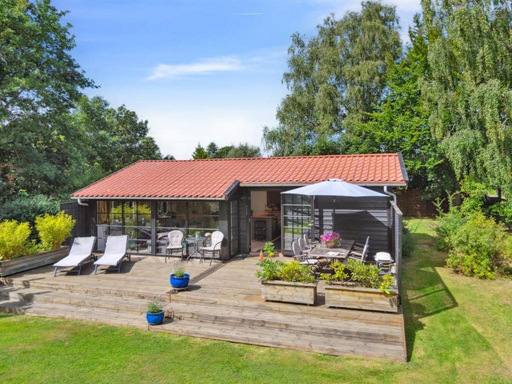 a wooden deck with a gazebo in a garden at Holiday Home Bedine - 1-3km from the sea by Interhome in Gilleleje