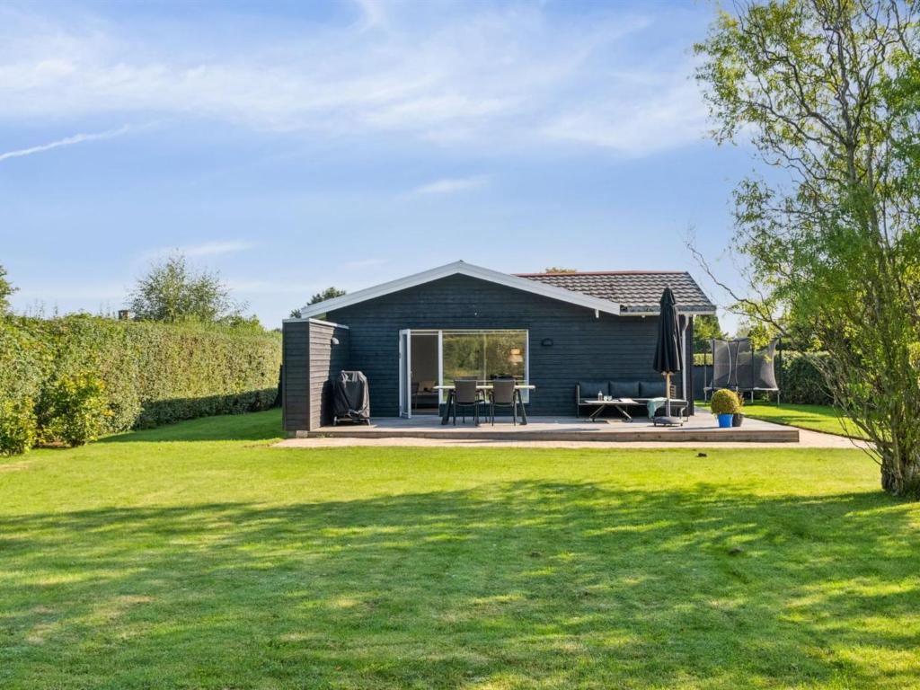 ein blaues Haus mit Rasen davor in der Unterkunft Holiday Home Frede - 1km from the sea by Interhome in Dronningmølle