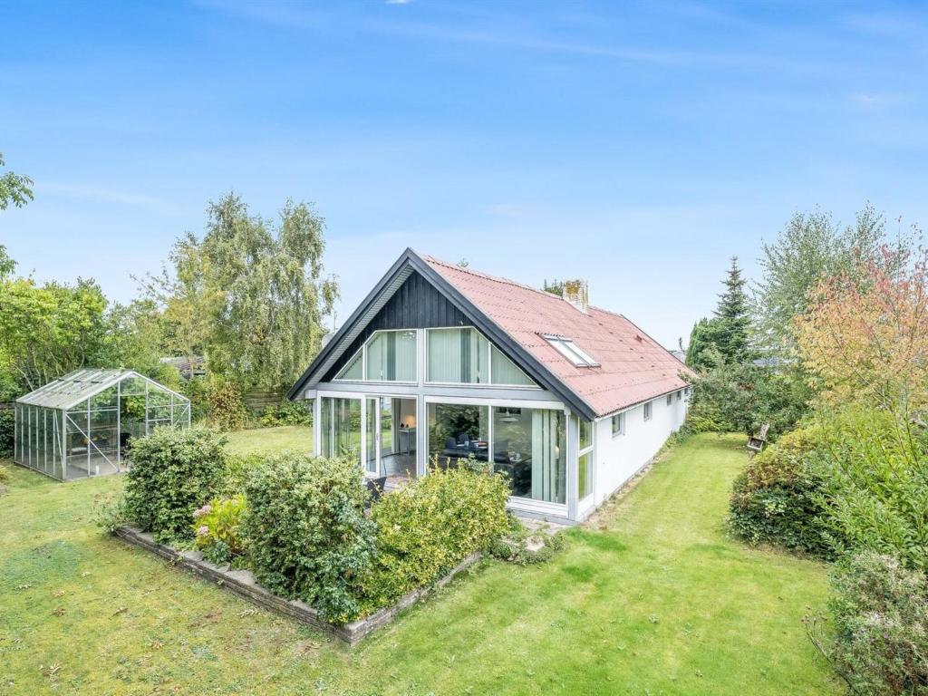 a house with a greenhouse in a yard at Holiday Home Frida - 125m from the sea by Interhome in Køge