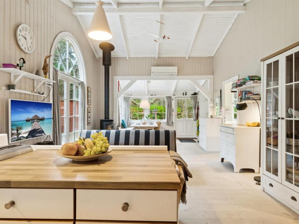 a kitchen and living room with a table with a bowl of fruit at Holiday Home Galathea - 175m from the sea by Interhome in Nykøbing Sjælland