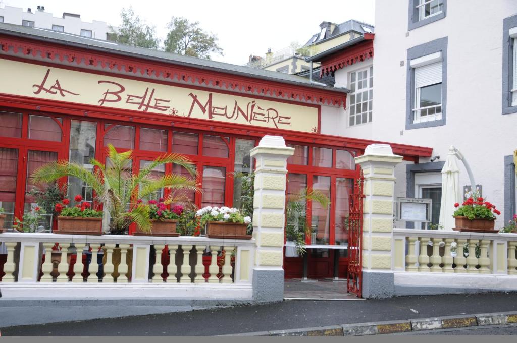 un bâtiment rouge avec une clôture blanche devant lui dans l'établissement La Belle Meuniere, à Royat