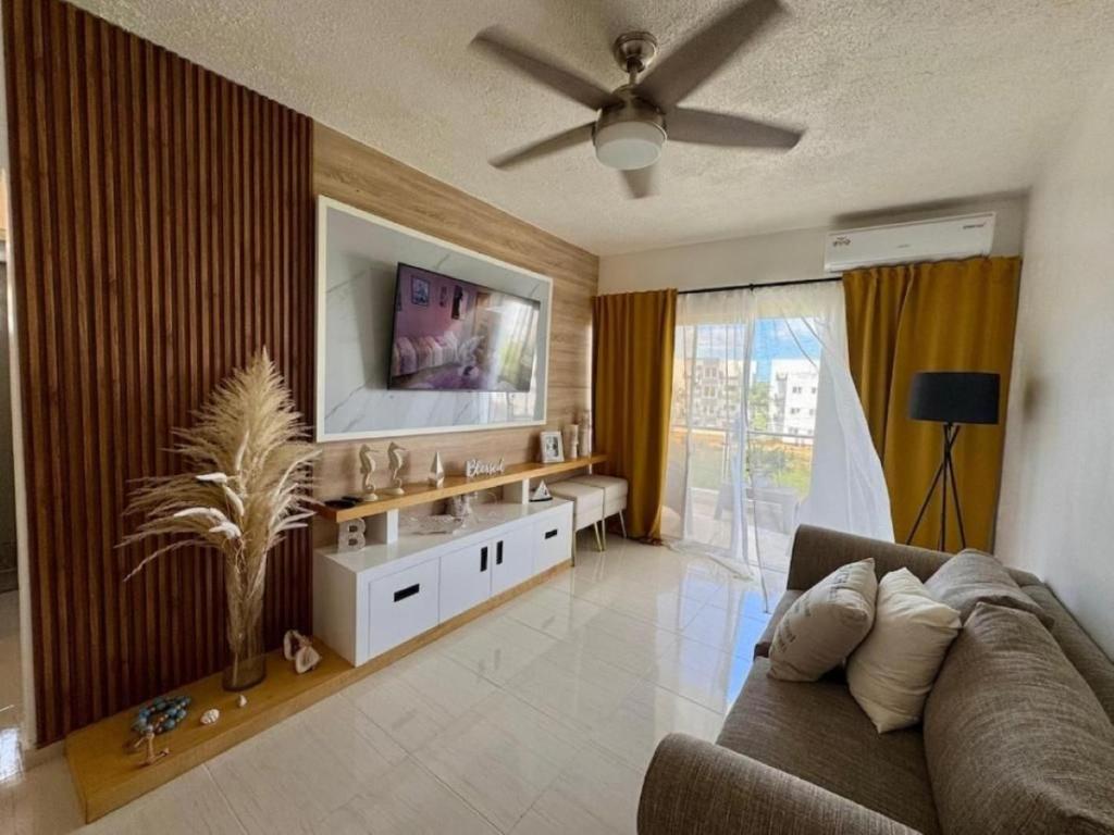 a living room with a couch and a flat screen tv at Bayahibe Apartment by the Beach in Bayahibe