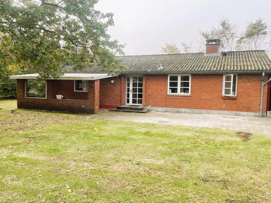 Una casa de ladrillo con un gran patio delante de ella. en Holiday Home Agla - 2-5km from the sea by Interhome, en Nørre Nebel