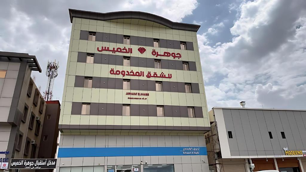 a building with a sign on the side of it at شقق جوهرة الخميس للشقق المخدومة in Khamis Mushayt