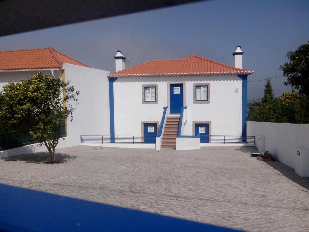 uma casa branca com uma porta azul e escadas em Casa da Camélia - Sintra em Sintra