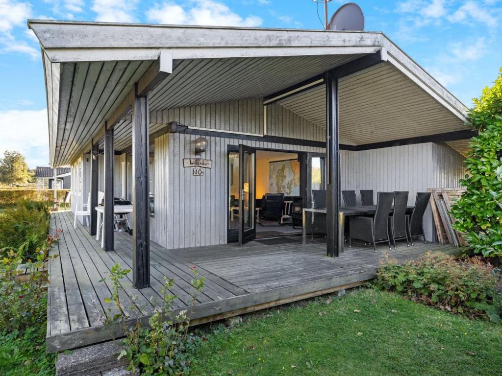 una casa con una terrazza in legno con sedie sopra di Holiday Home Kajsa - 250m from the sea by Interhome a Svendborg