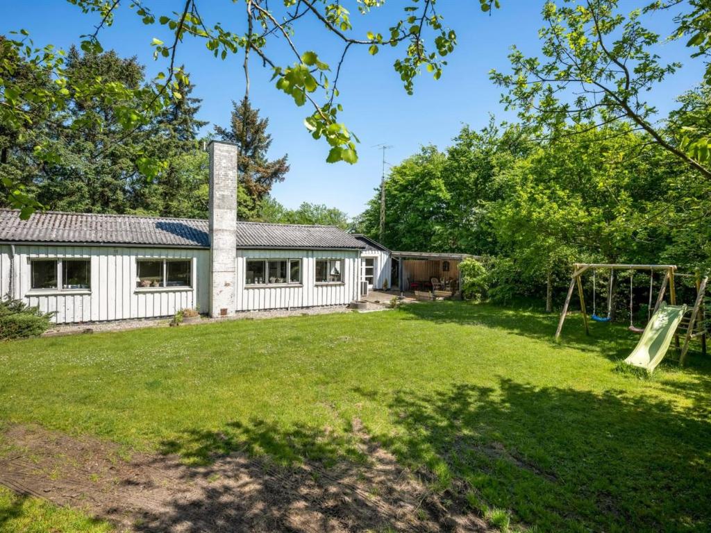a house with a yard with a playground at Holiday Home Landolf - 800m from the sea by Interhome in Blåvand