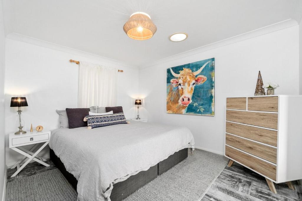 une chambre avec un lit et une peinture d'une vache dans l'établissement Cottage dAmour Waterfront, à Spencer