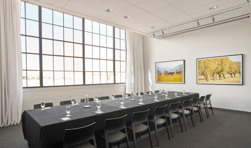 a long table and chairs in a room with windows at Fordson Hotel, in the Unbound Collection by Hyatt in Oklahoma City