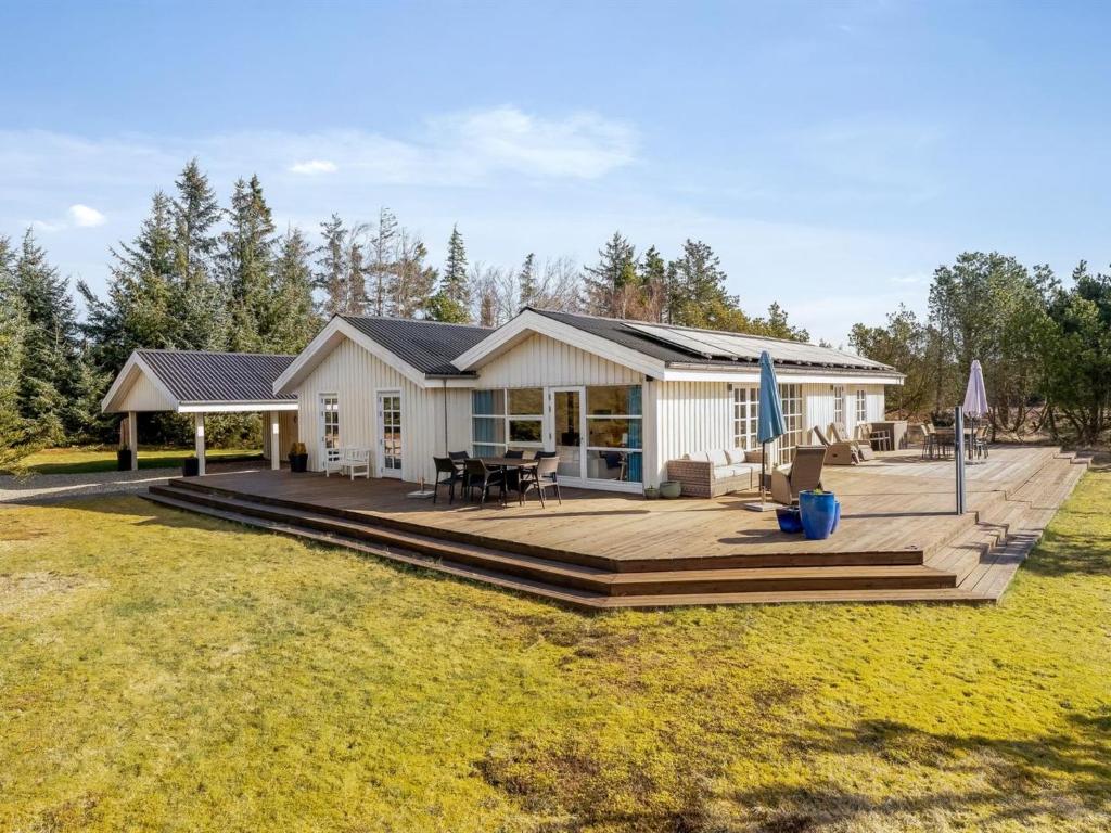 een huis met een terras en een huis bij Holiday Home Toska - 3km from the sea by Interhome in Blokhus