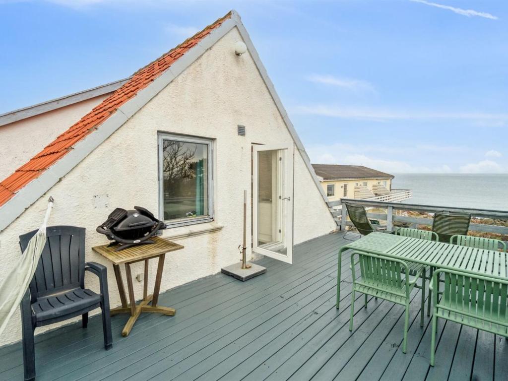 a house with a deck with chairs and a table at Apartment Drude - 50m from the sea by Interhome in Allinge
