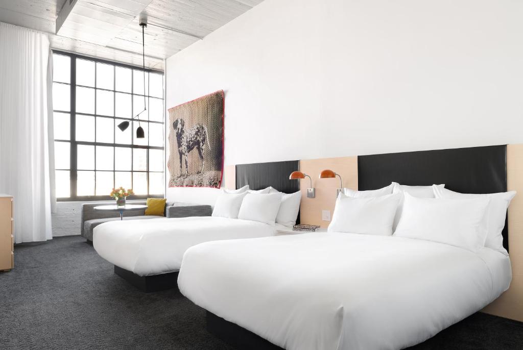 two beds in a hotel room with white pillows at Fordson Hotel, in the Unbound Collection by Hyatt in Oklahoma City