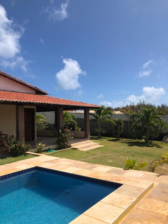 a swimming pool in front of a house at Casa dunas in Guajiru