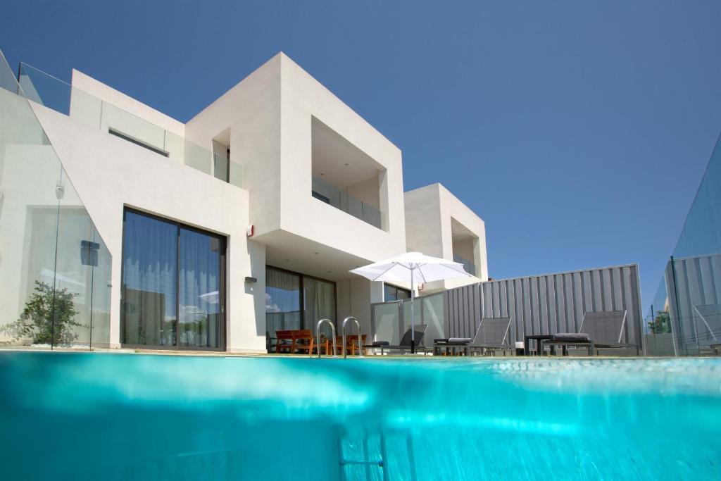 a house with a swimming pool in front of a building at S&K Villas in Kalamaki Chanion
