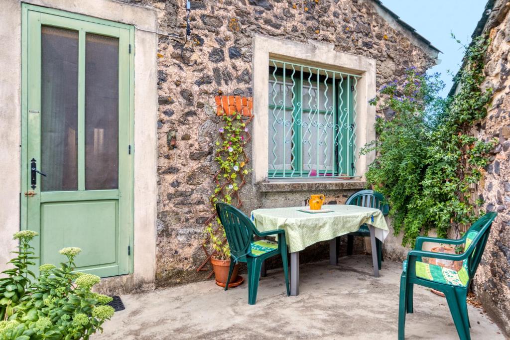 une table et des chaises devant un bâtiment avec une porte verte dans l'établissement La Coustouline, à Lacoste