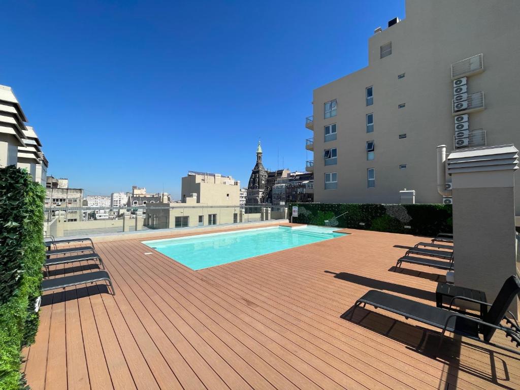 a swimming pool on a deck next to a building at Ayres Suites Moreno in Buenos Aires