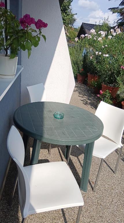a green table and two white chairs and a table and chairs at Apartmany Fantagiro in Kaluža