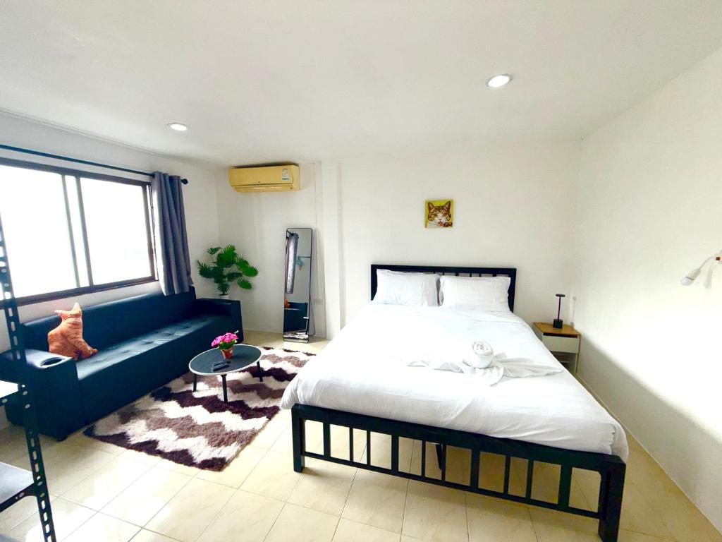 una camera da letto con un letto e un divano blu di Patong Canal Villa 302 a Patong Beach