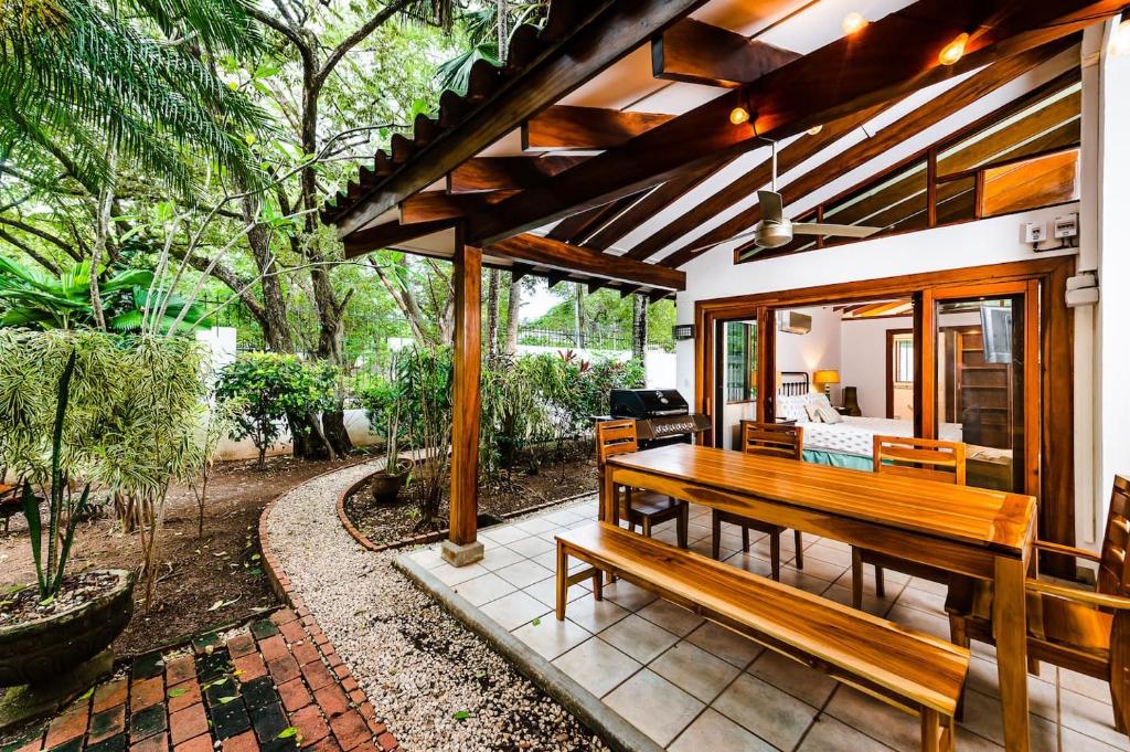 a patio with a wooden table and benches at Hidden Oasis Across The Street From The Beach in Tamarindo