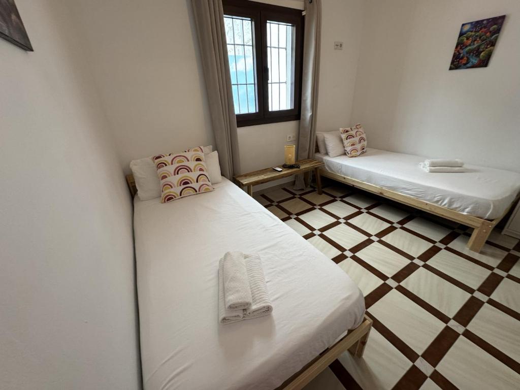 a room with two beds and a tiled floor at Casa Flamenco - Casco Antiguo in Antequera