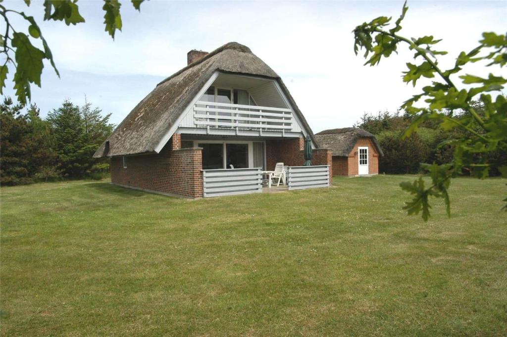 an old house with a thatched roof on a field at 20040-Ulfborg-Sundhuse-15 in Ulfborg