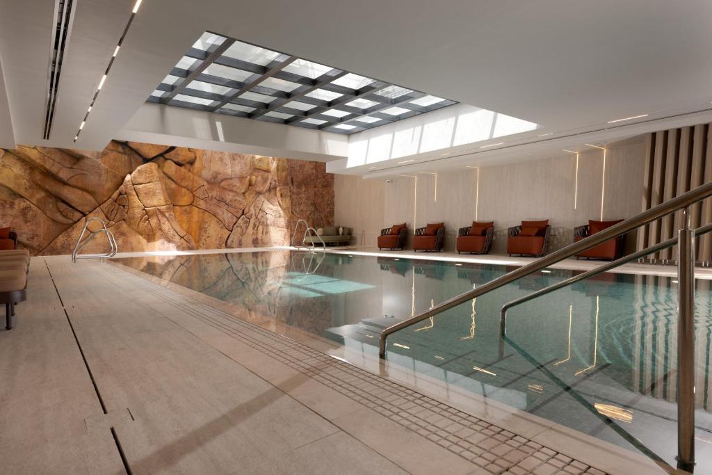 a swimming pool in a building with a rock wall at Yalarent Amazing apartments U360 Complex Eilat in Eilat