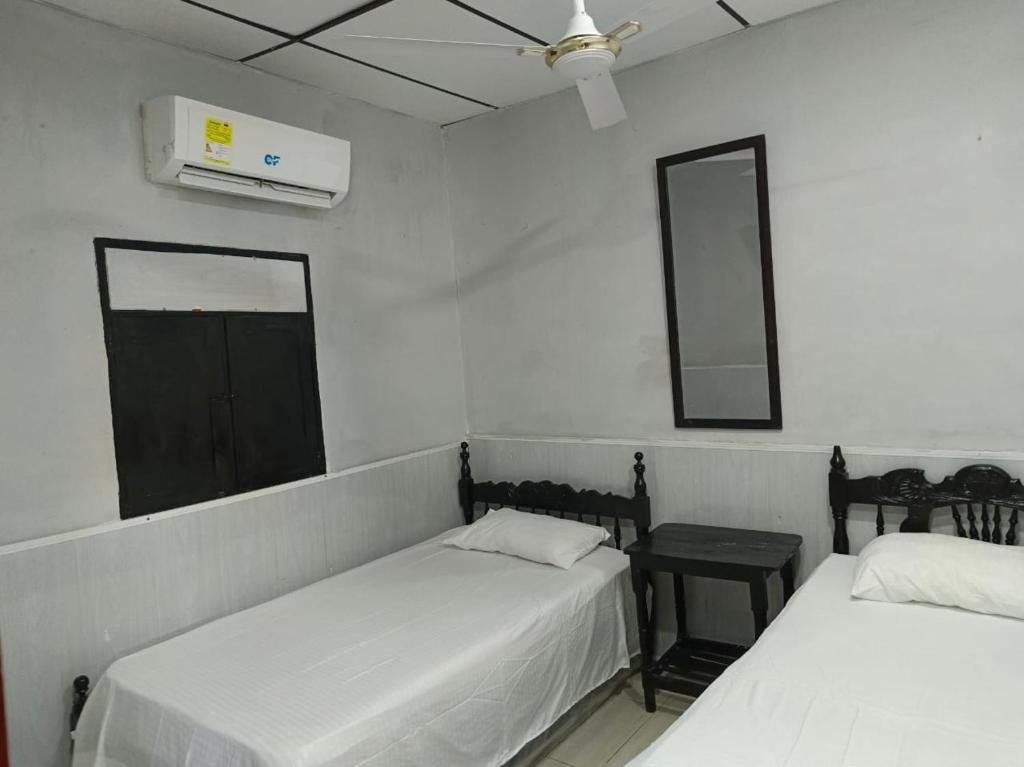 a room with two beds and a mirror and a window at Casa S&J in Mompos