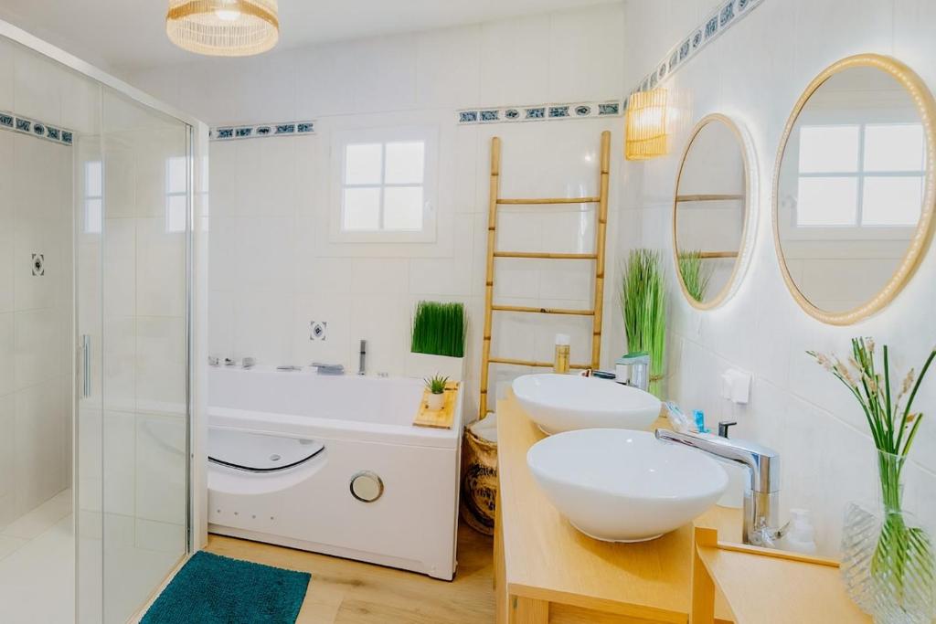 a white bathroom with two sinks and a shower at Évasion à Rully grande maison avec piscine privée in Rully