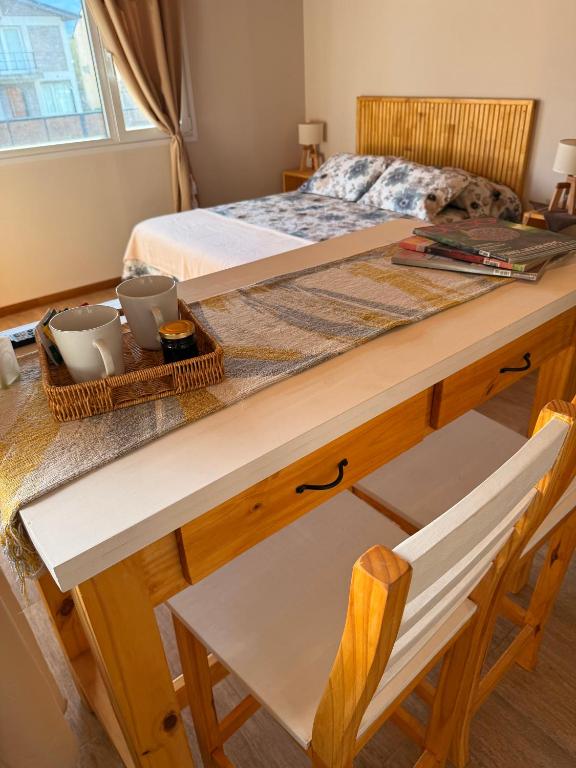a bedroom with a bed and a table and a chair at Apart Patagonia Bolson in El Bolsón
