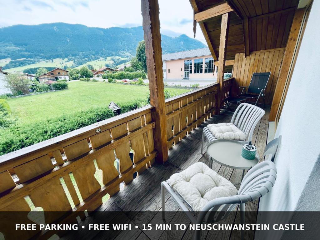a deck with chairs and a table and a view at Traumblick bis 8 Gäste und schlossnah in Halblech