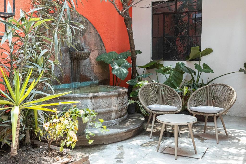 プエブラにあるBeautiful House in Historic Center 5 bedroomsの中庭(椅子2脚、噴水付)