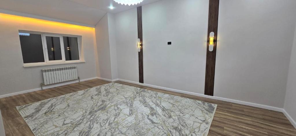 une pièce vide avec un tapis sur le sol dans l'établissement Жк Кербез, à Aktau