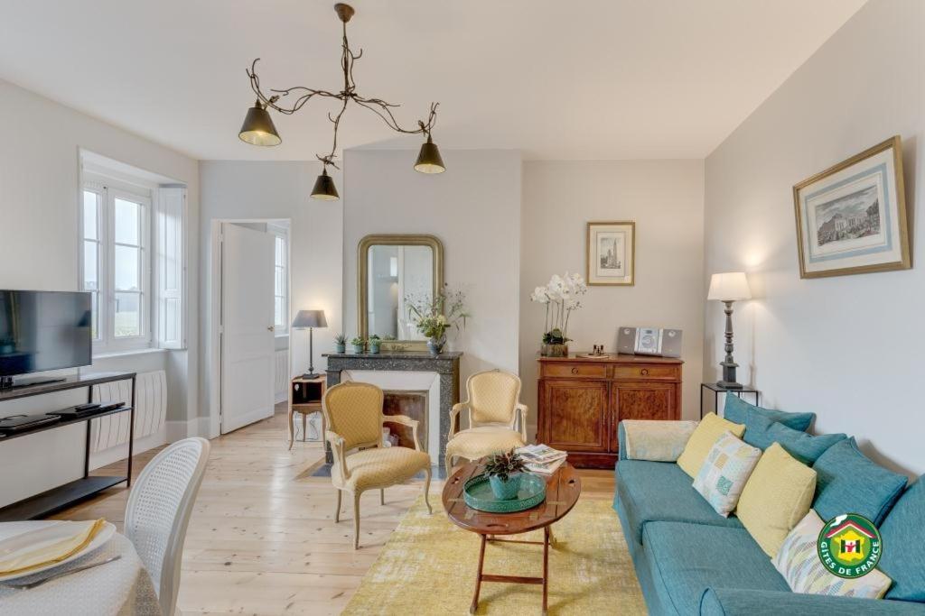 ein Wohnzimmer mit einem blauen Sofa und einem Tisch in der Unterkunft Vue sur chantilly in Chantilly