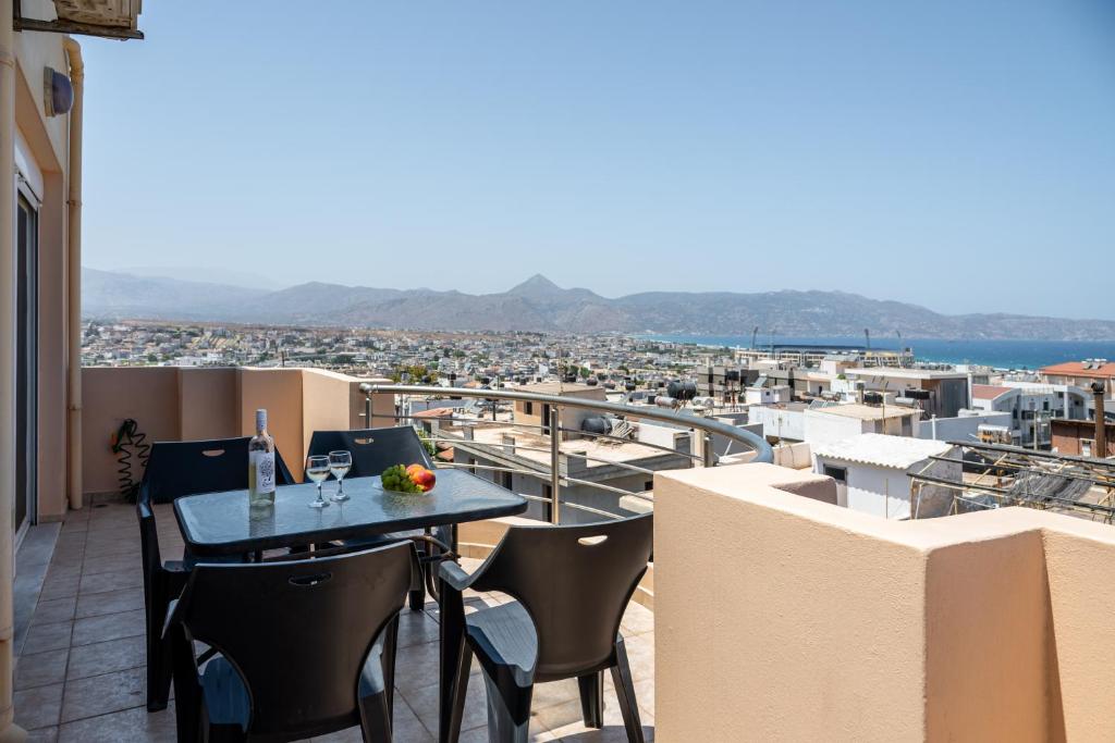 a table and chairs on a balcony with a view at Eagles Nest Panoramic SeaView Apartment in Thérissos