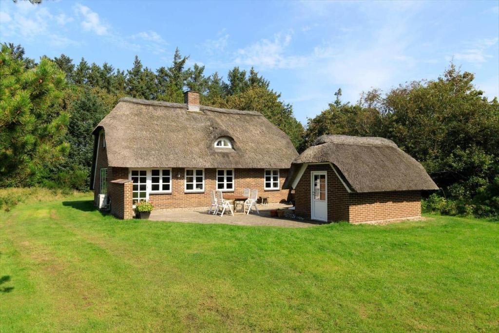 a brick house with a thatched roof on a field at 10294-Ulfborg-Gaffelbjergvej-44 in Øhuse