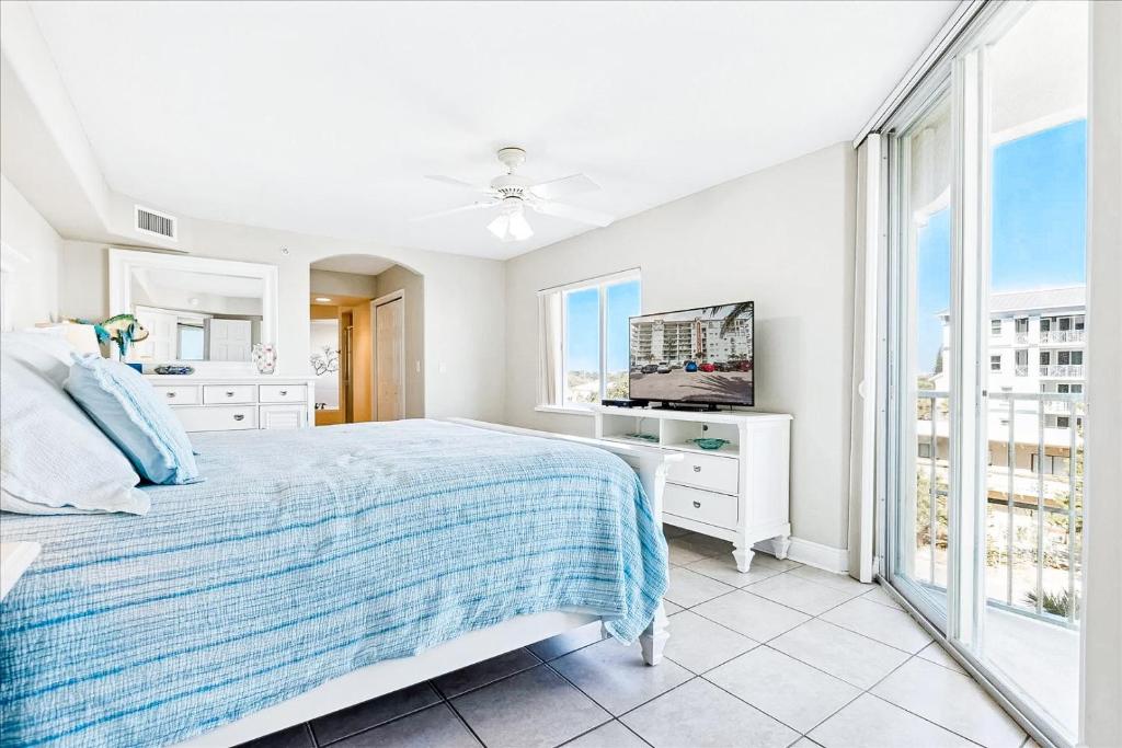 a white bedroom with a bed and a television at Michelina 406 in Cape Canaveral